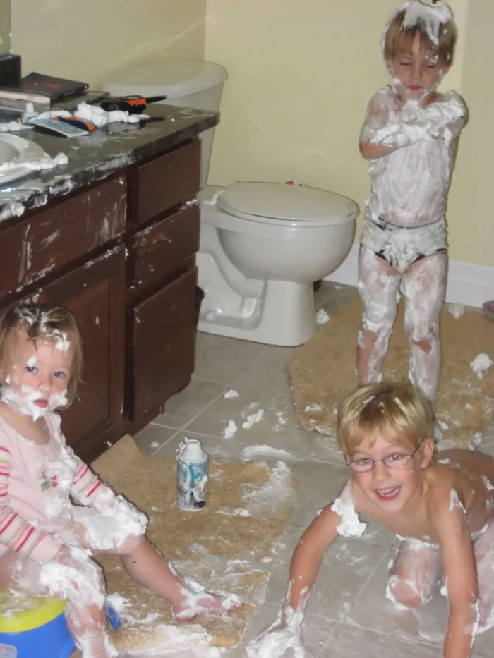 Kids covered in shaving cream in a bathroom, showing what happens when kids are left alone for a moment.