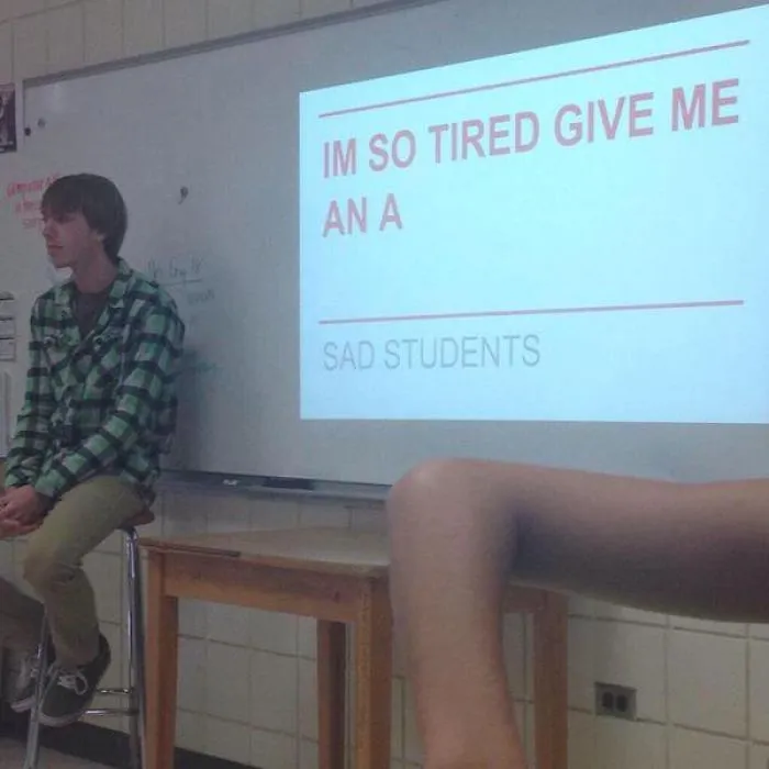 Person giving a presentation and writes I'm so tired give me an A