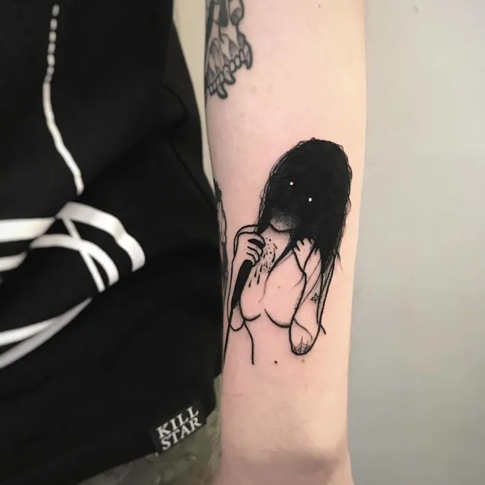 Tattoo of a faceless girl on an arm, featuring dark hair and blank eyes, with a slightly erotic design.