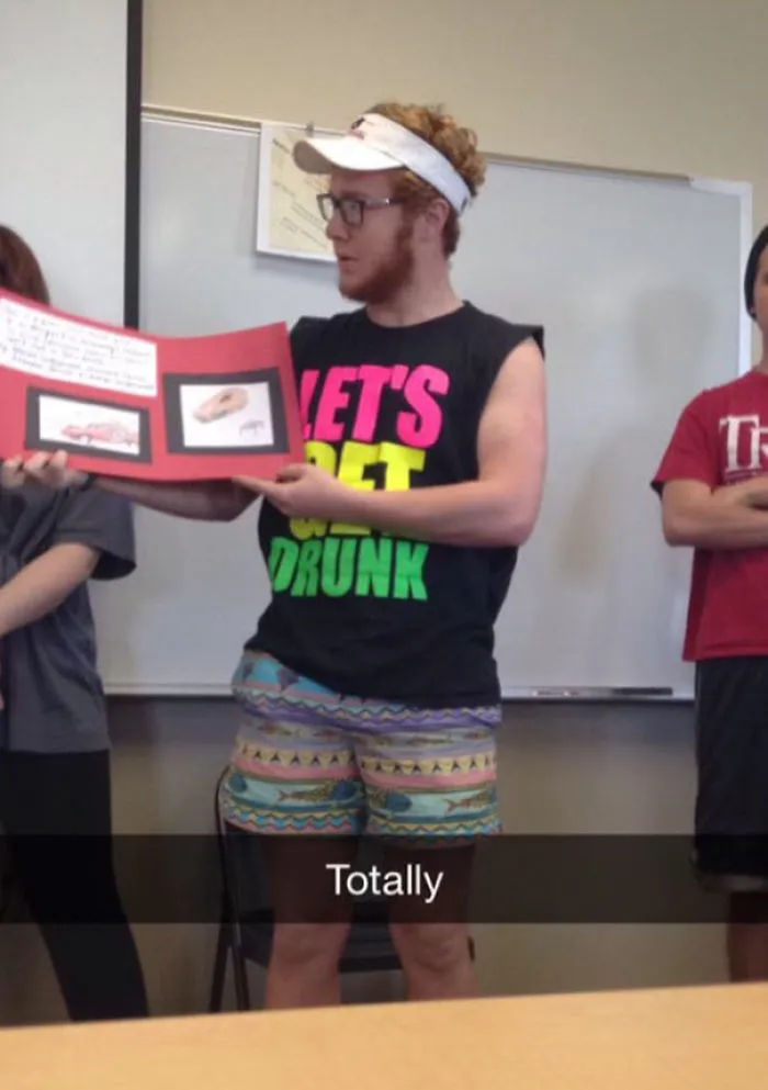 Person wearing lets get drunk shirt and giving an presentation