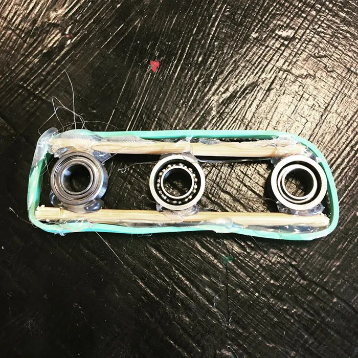 Este niño se ha hecho un spinner casero con la rueda de un yoyo, palillos, una goma elástica y cola caliente