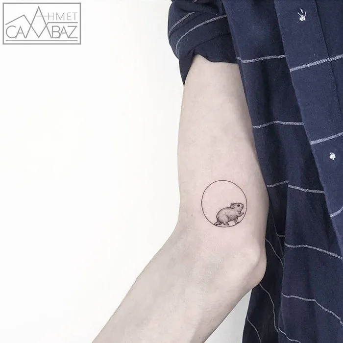 Minimalist rodent tattoo design by former Turkish cartoonist on forearm.