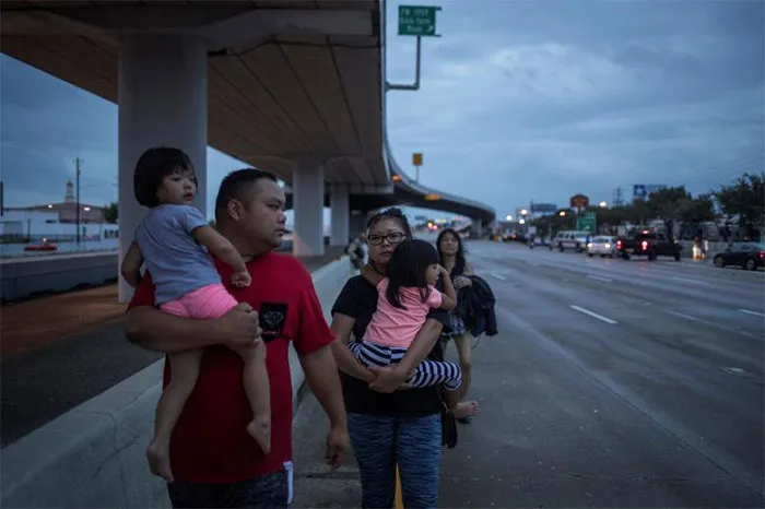 The Duong Family Walks Along Interstate 45 While Escaping Flood Waters In Houston, Texas