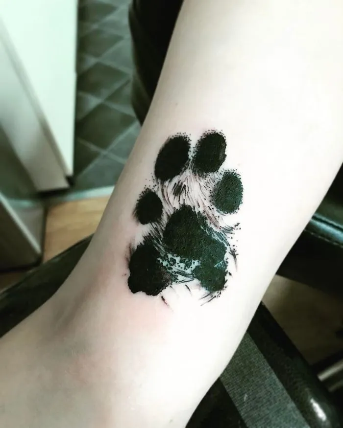Dog paw print tattoo on a person's arm, showcasing its artistic and expressive design.
