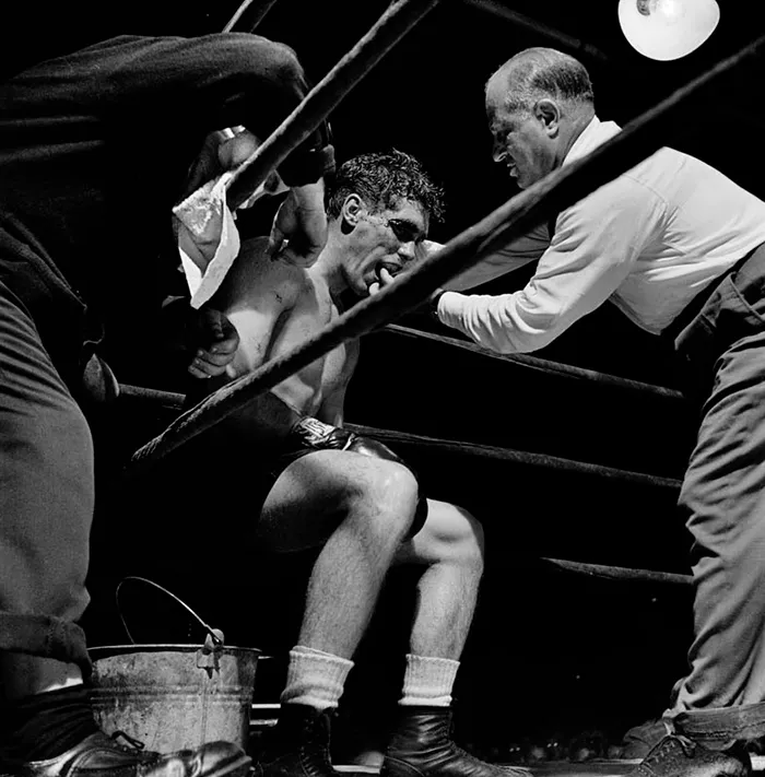 Boxer in a corner with trainer, captured by Stanley Kubrick in 1940s New York, showcasing his early genius in photography.