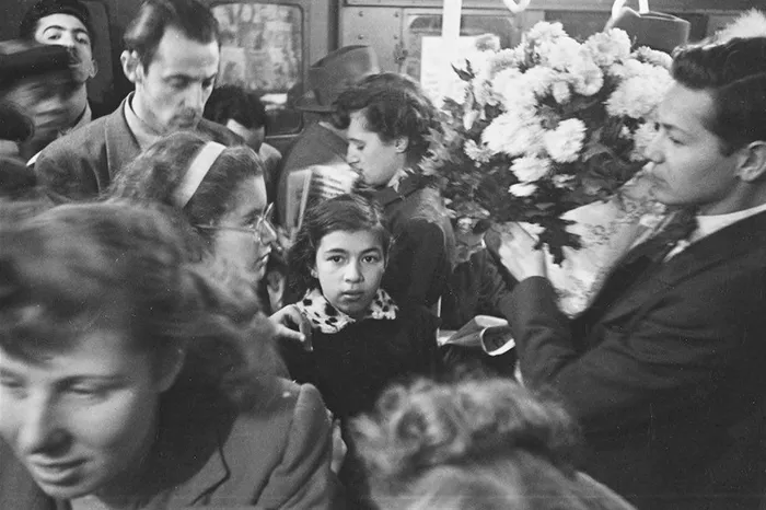 New York 1940s subway scene, a young girl surrounded by commuters, captured in a photo by Stanley Kubrick.