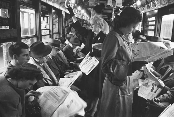 People in 1940s New York subway, reading newspapers, showcasing Stanley Kubrick's early photography genius.