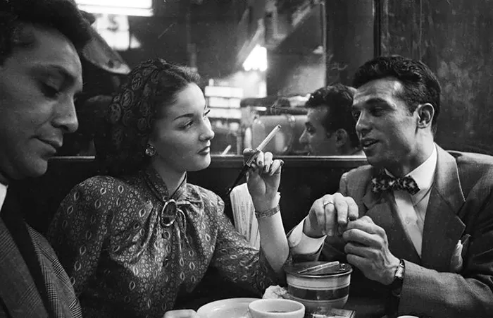1940s New York cafe scene, three people in conversation, showcasing young Stanley Kubrick's photography skills.