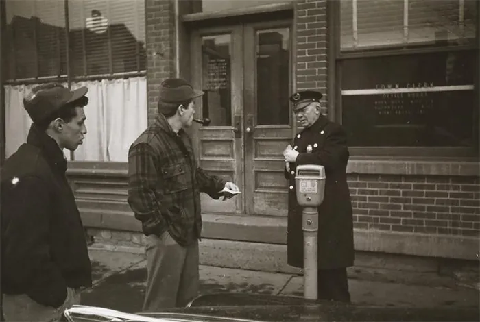 1940s New York scene captured by Stanley Kubrick, showing a policeman and two men by a parking meter.