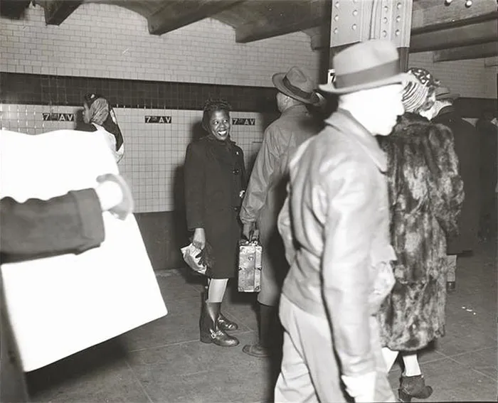 1940s New York subway scene captured by teenage Stanley Kubrick, showing people in motion and a woman smiling.