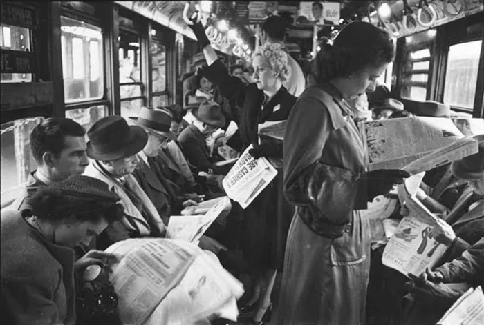 1940s New York subway scene captured by young Stanley Kubrick, passengers reading newspapers.