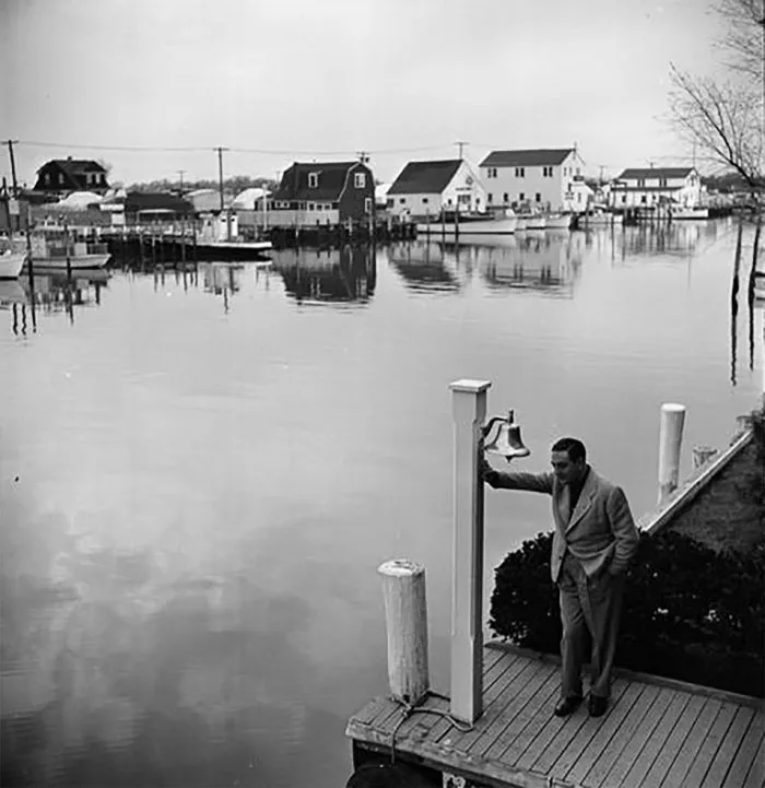 1940s New York waterfront scene by 17-year-old Stanley Kubrick, featuring a man leaning on a post by the water.