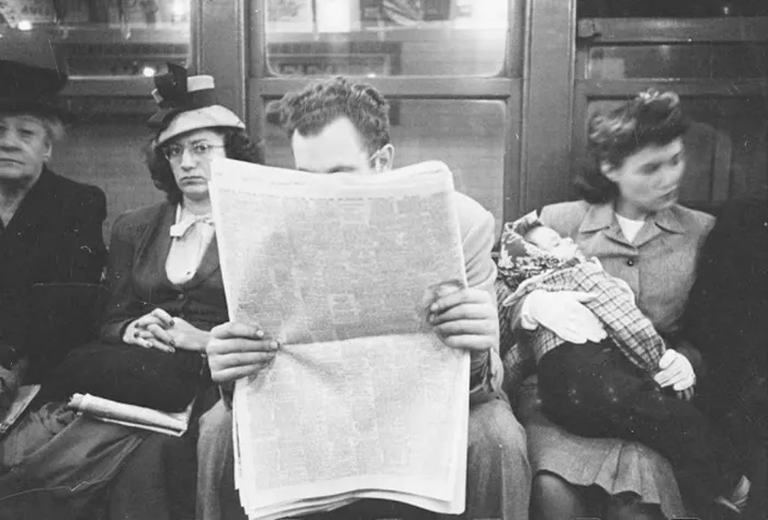 People on a 1940s New York subway, one reading a newspaper, depicting early Stanley Kubrick’s photography.