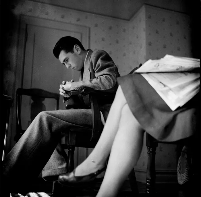 Young man in 1940s New York, seated in a room. Iconic photo showcasing early talent.