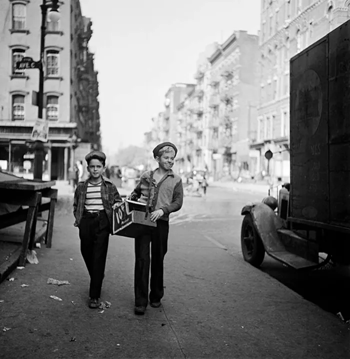 Two boys walk in 1940s New York, captured in a black and white photo by young Stanley Kubrick.