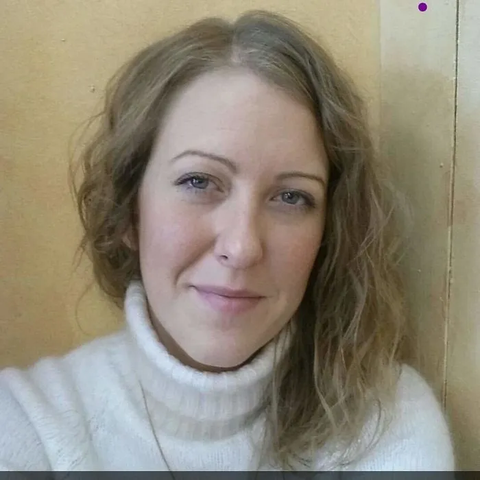 A woman with a neutral expression, wearing a white sweater, illustrating the invisible symptoms of depression.
