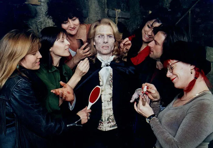 Behind the scenes of Interview With The Vampire movie with makeup artists applying details on the vampire actor’s face.