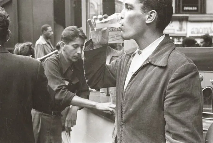 1940s New York scene, young man drinking, captured by Stanley Kubrick, showcasing early photographic genius.