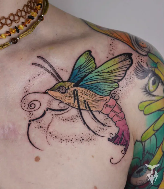 Tattoo featuring a colorful butterfly and floral elements, inspired by nature and Art Nouveau styles.