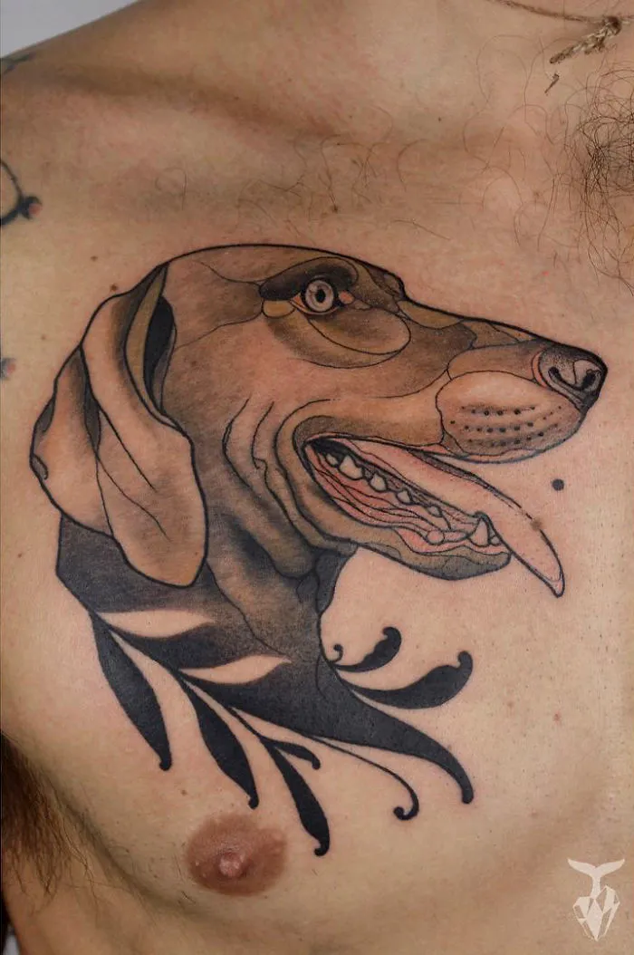 Nature and Art Nouveau inspired tattoo of a stylized dog head on a person's chest.