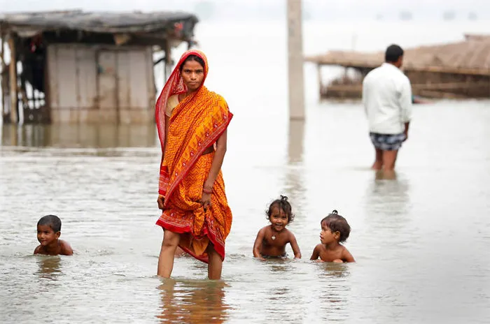 A Woman Walks Through A Flooded Village In Motihari, Bihar State, India