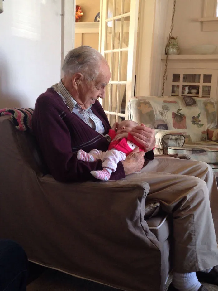 Anciano de 98 años sosteniendo a su bisnieta de 1 semana por 1ª vez