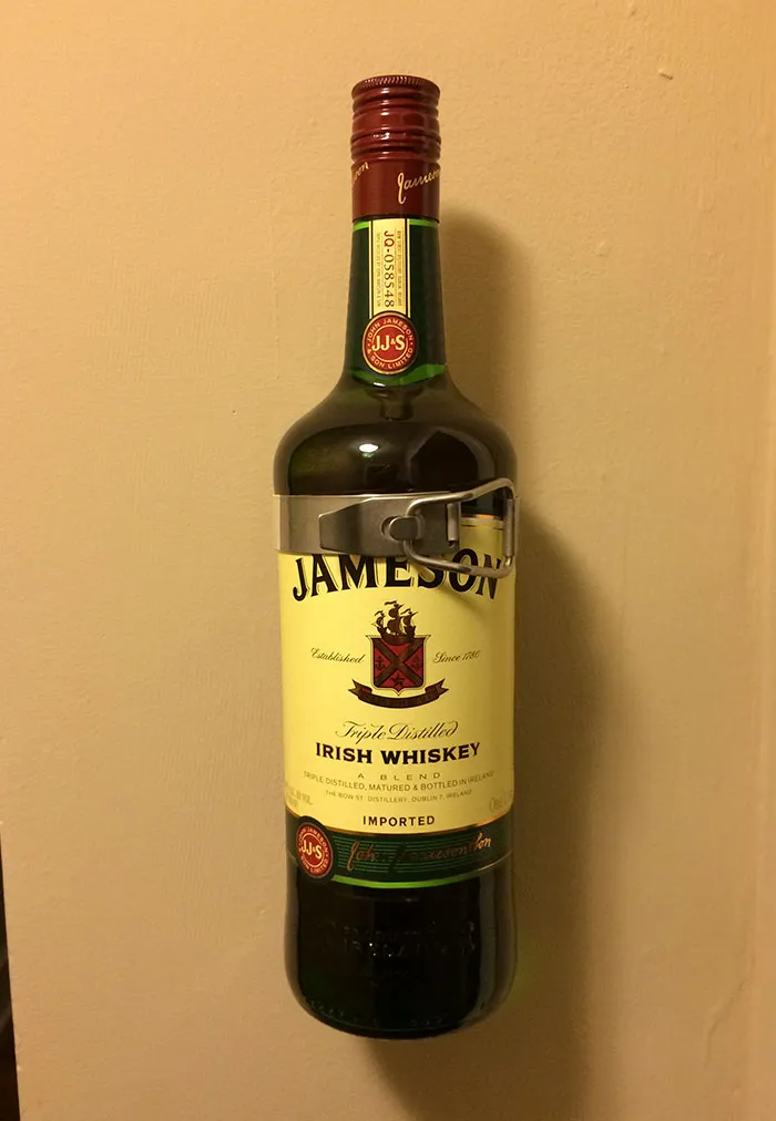 Botella de whisky que encaja perfectamente en la sujección del extintor