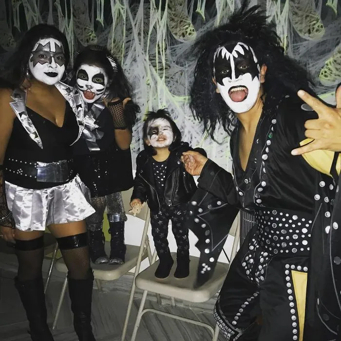 A family posing together in rock star KISS Halloween costumes.