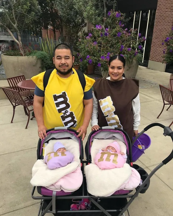 Parents dressed as M&M candies with twin infants in M&M Halloween costumes