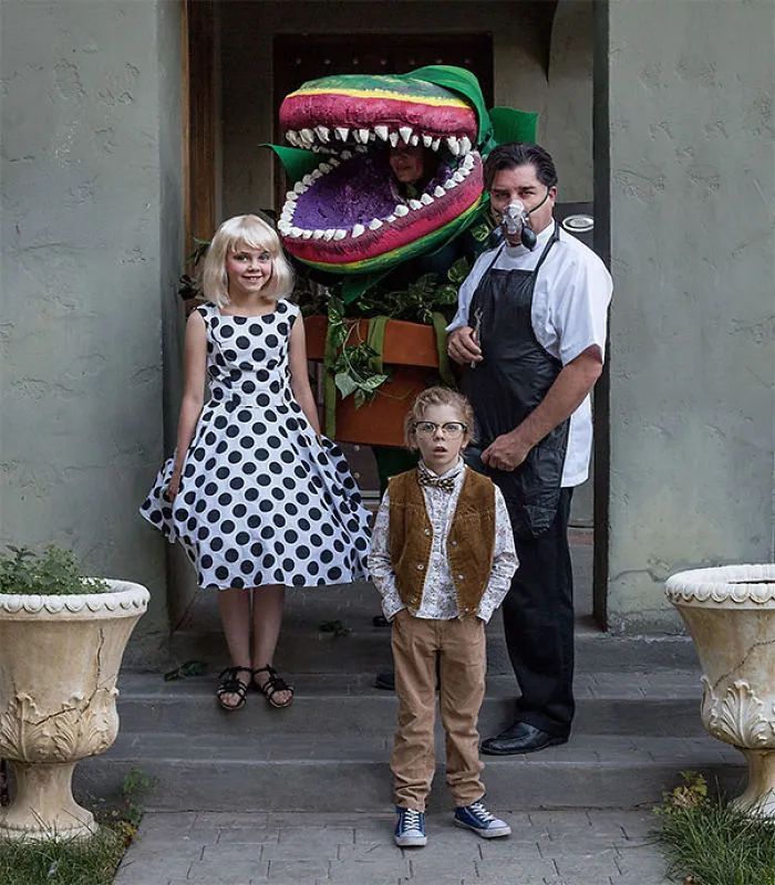 A family posing on front steps wearing detailed Little Shop of Horrors family Halloween costumes.