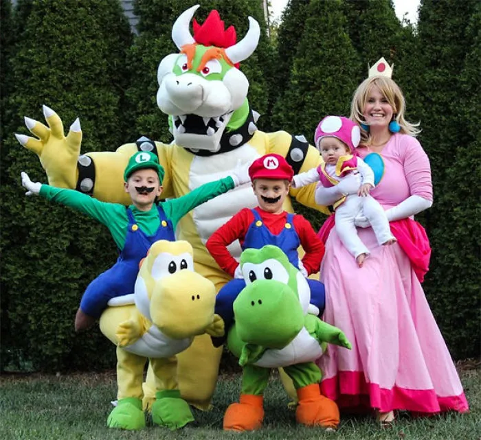 Family dressed in colorful Super Mario character Halloween costumes outdoors
