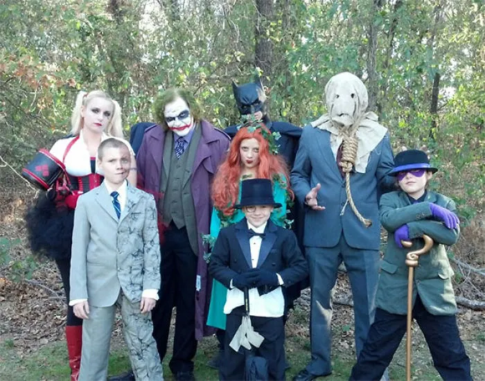 A family dressed in Batman villain theme Halloween costumes outdoors