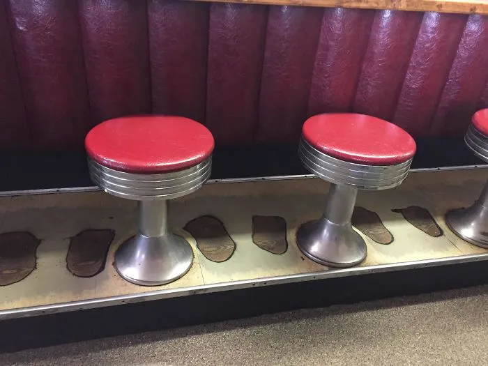 Suelo desgastado por los pies de clientes en una cafetería