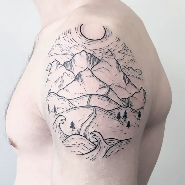 Mountain and ocean travel tattoo on upper arm, featuring waves, road, trees, and crescent moon.