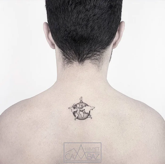 Minimalist world map tattoo on a person's upper back, symbolizing travel inspiration.