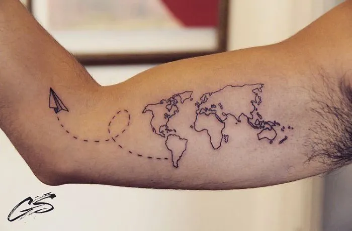 Travel tattoo depicting a world map with a paper airplane design on an arm.