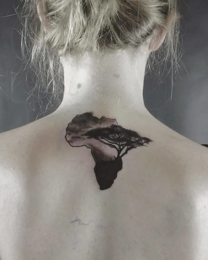 Back tattoo of Africa with a tree, featuring travel-inspired design elements.