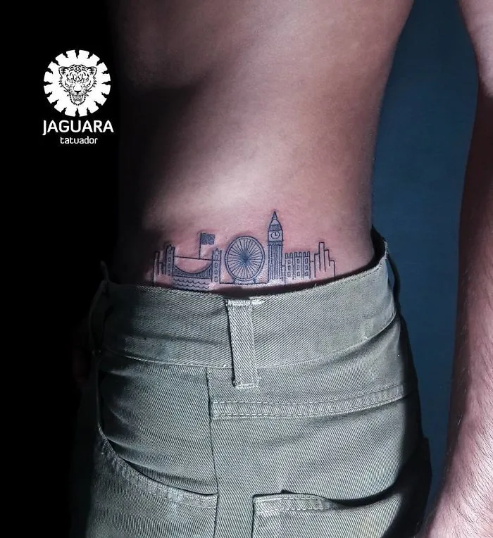 Travel tattoo featuring a city skyline inked on the lower back, inspiring wanderlust.