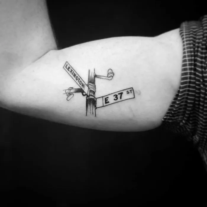 Travel tattoo of Lexington and E 37 St signs on an arm, inspiring wanderlust and adventure.