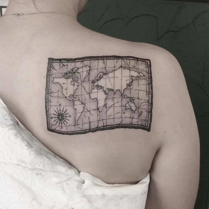 World map tattoo on upper back symbolizes travel inspiration and wanderlust.