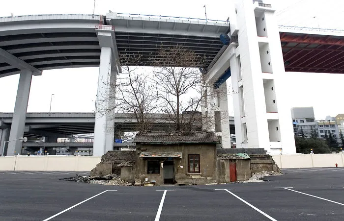 The Last House Of An Old Neighborhood Stands Alone In A Future Shanghai World Expo 2010 Parking Lot, Under Nanpu Bridge On April 6, 2010, In Shanghai, China. The Holdout Owner Of The House Was Shi Yuji. The House Was Destroyed Days Later, And The Owner Moved Into A Workers' Dormitory