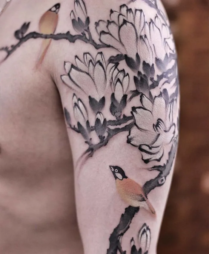 Watercolor tattoo on arm featuring intricate floral and bird design by Chen Jie.