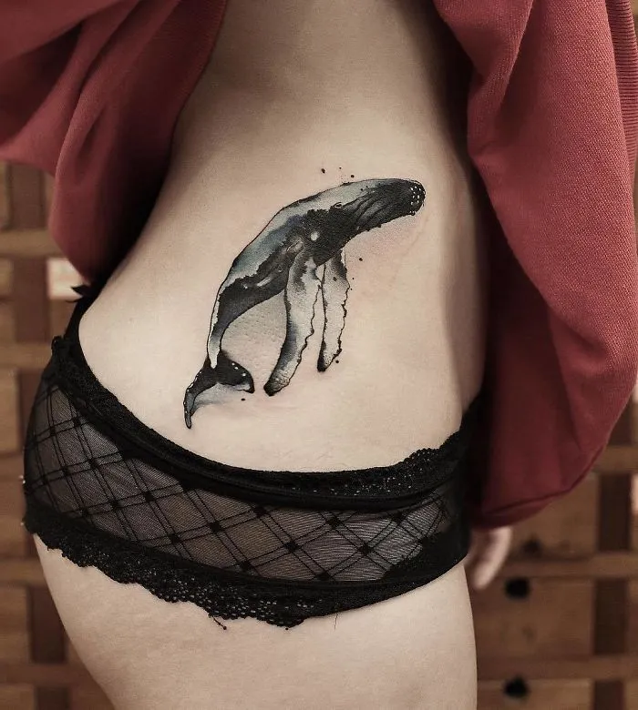 Watercolor tattoo of a whale on a person's side, showcasing Chen Jie's tattoo art.