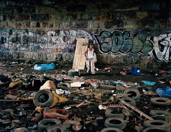 Photography of Eric Kyle posing near graffitti wall