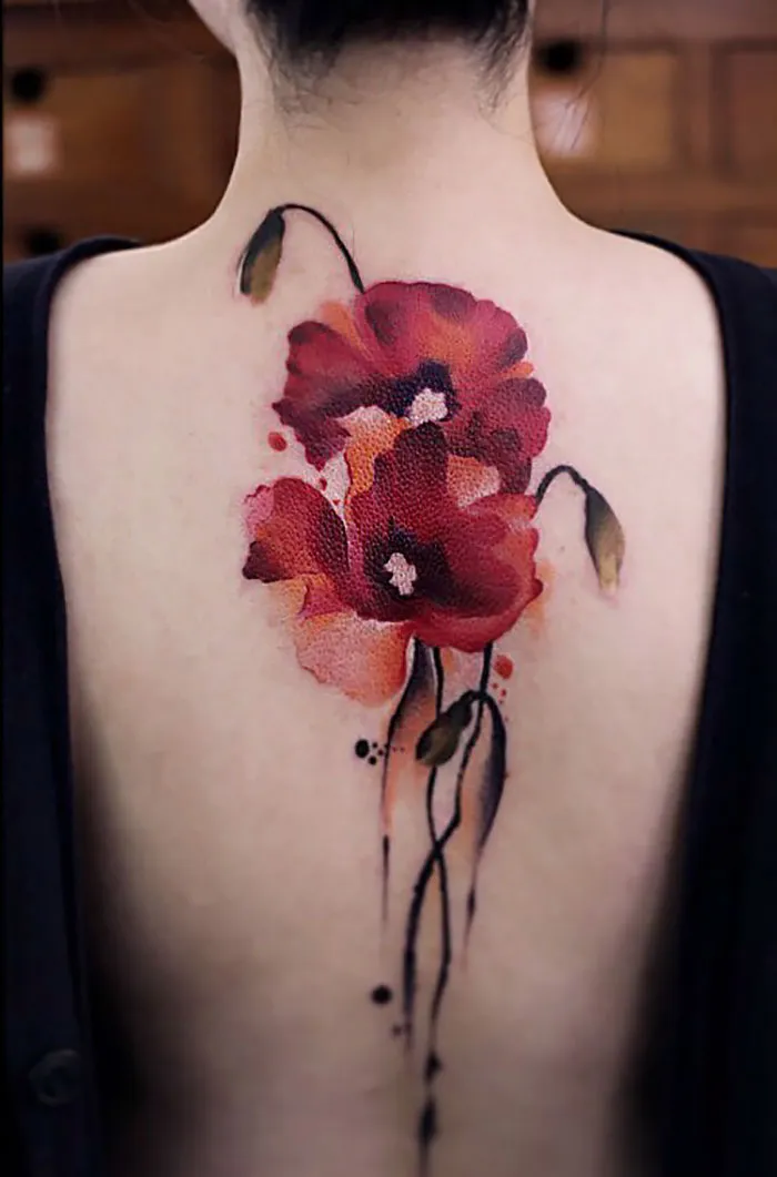 Watercolor tattoo of red flowers on a person's back, showcasing artistic ink style by Chen Jie.