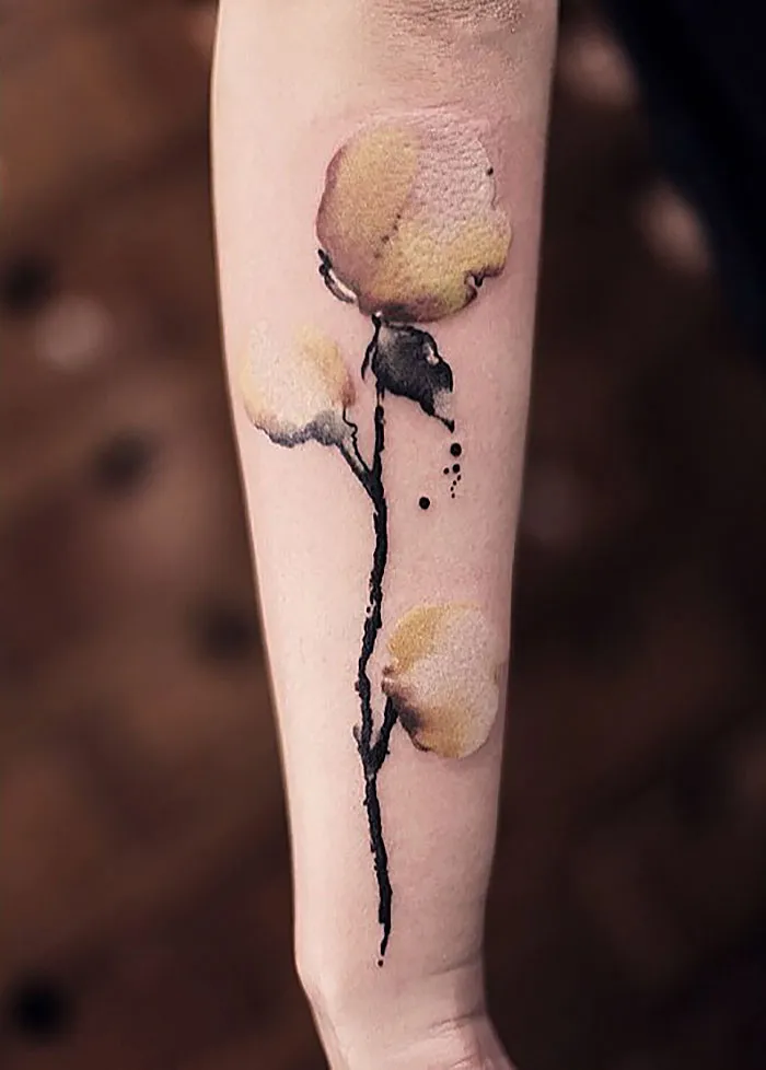 Watercolor tattoo by Chen Jie featuring delicate yellow flowers on an arm.