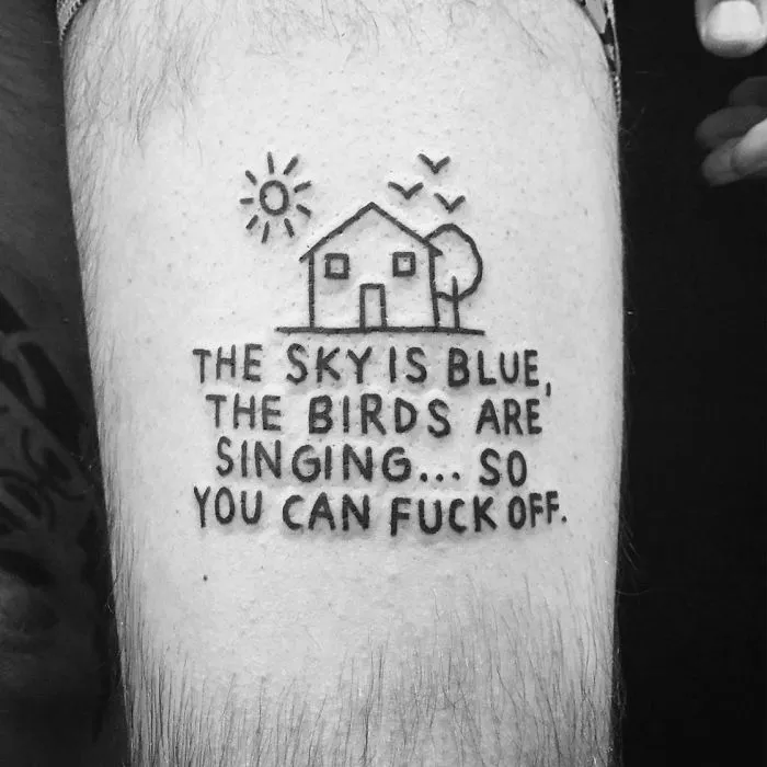 Irreverent tattoo by German artist features doodle of a house with humorous text underneath.