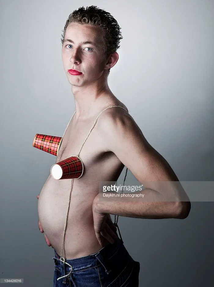Teenage boy with red lipstick and paper cups on his breasts