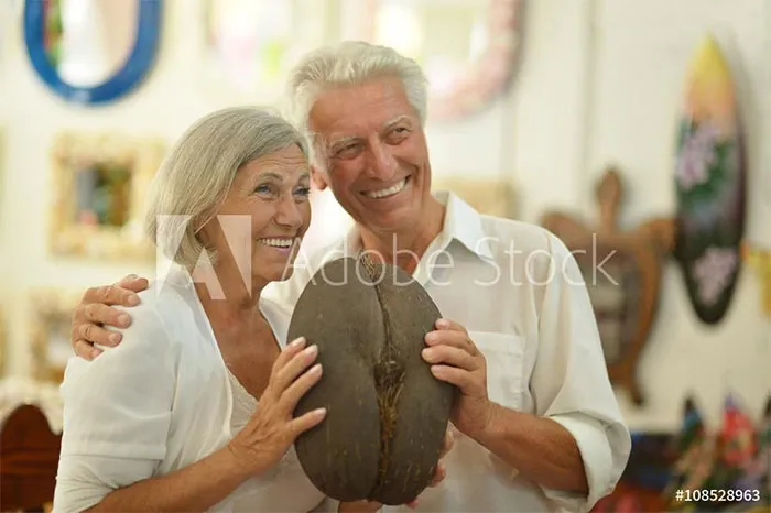 Happy older couple are holding elephant butt replica