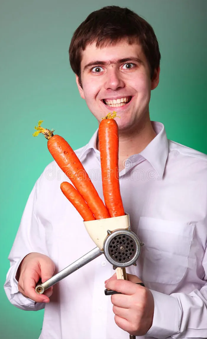 Excited teenager grinding three carrots